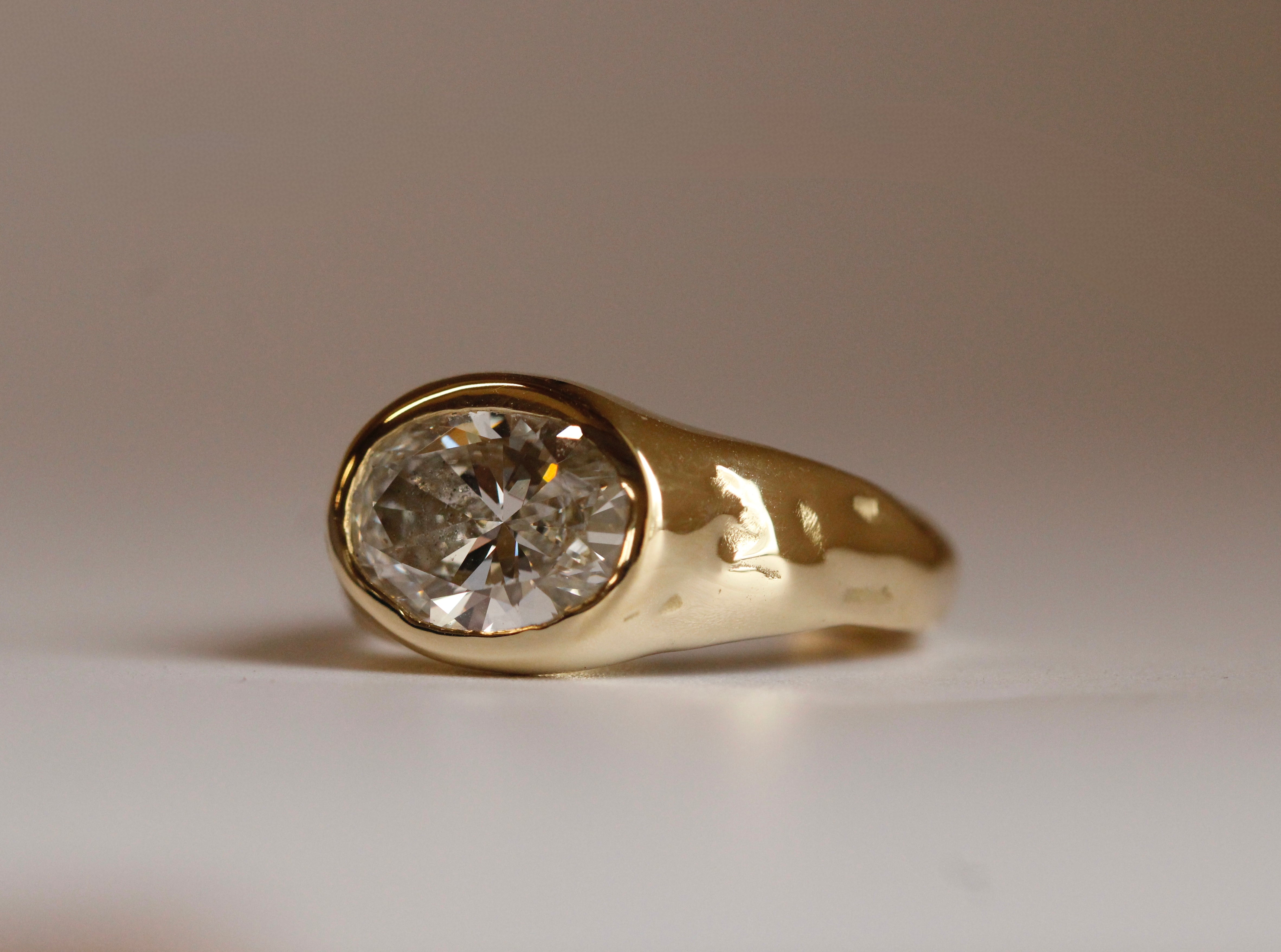 Gold ring with a diamond on a neutral background