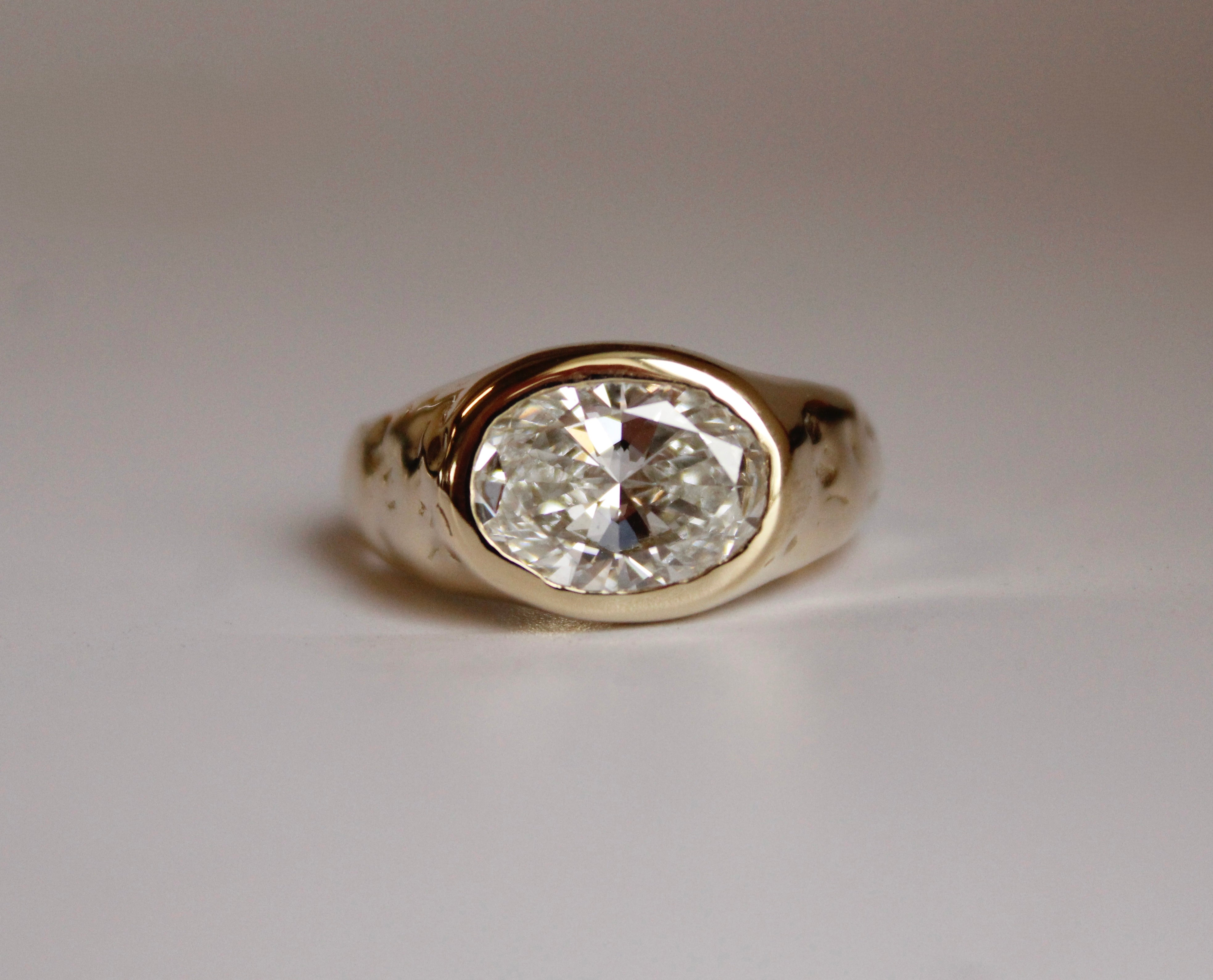 Gold ring with a diamond on a light gray background