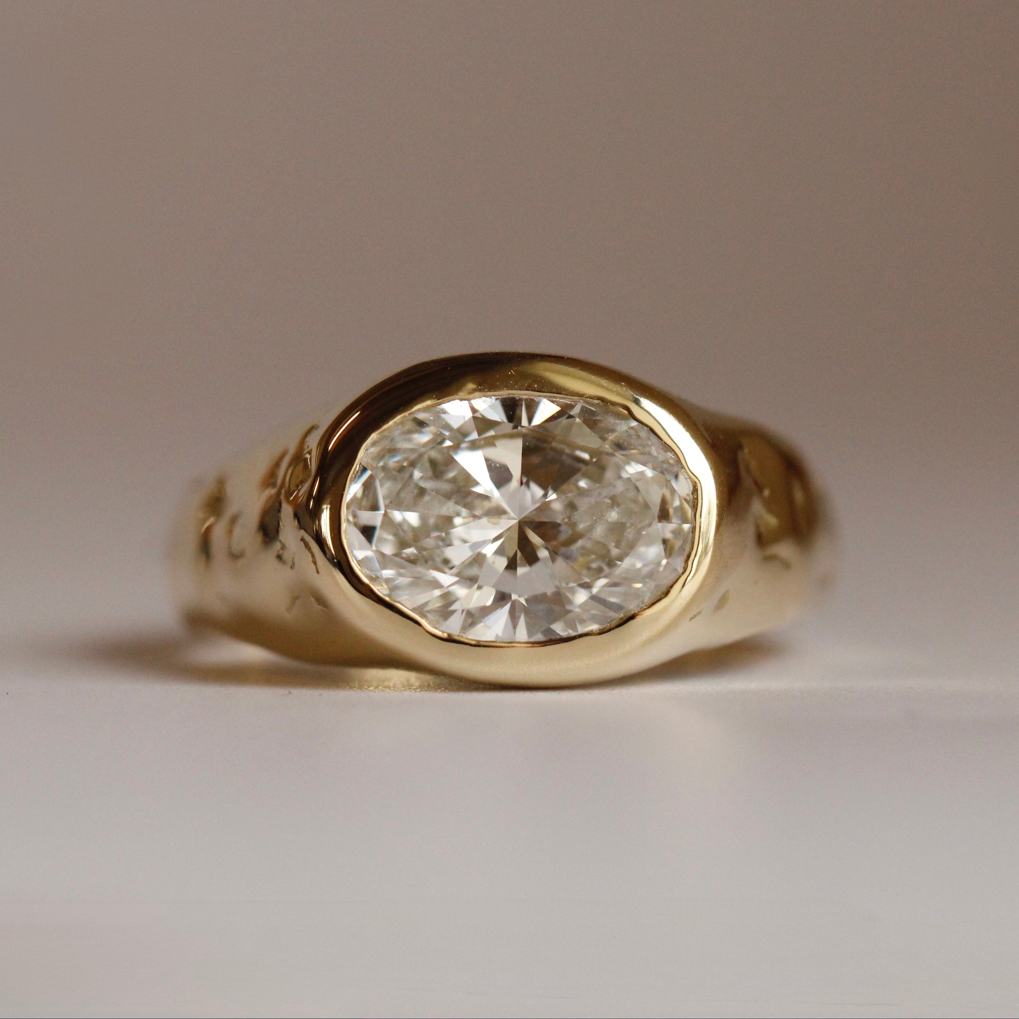Gold ring with a diamond on a neutral background