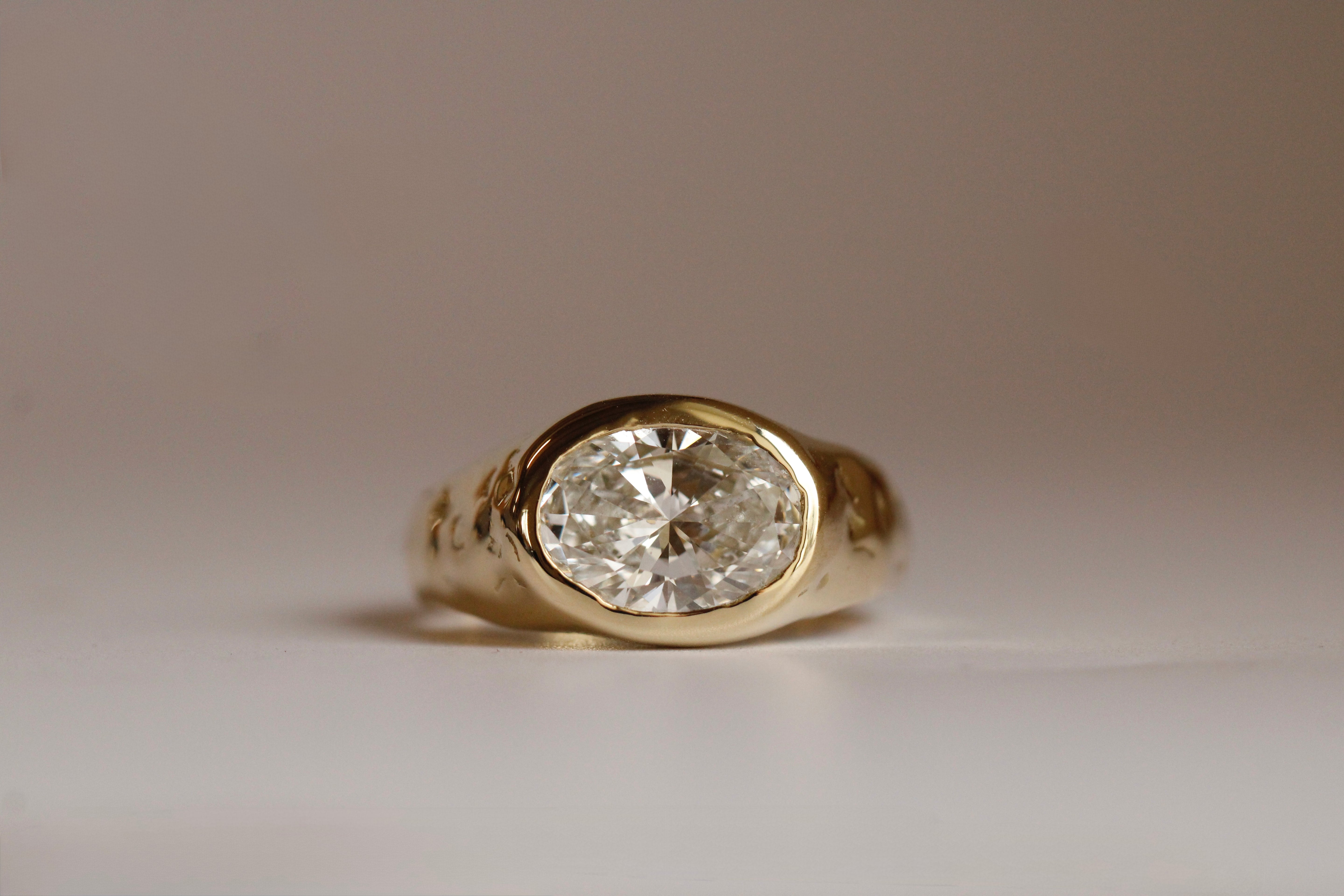 Gold ring with a diamond on a neutral background