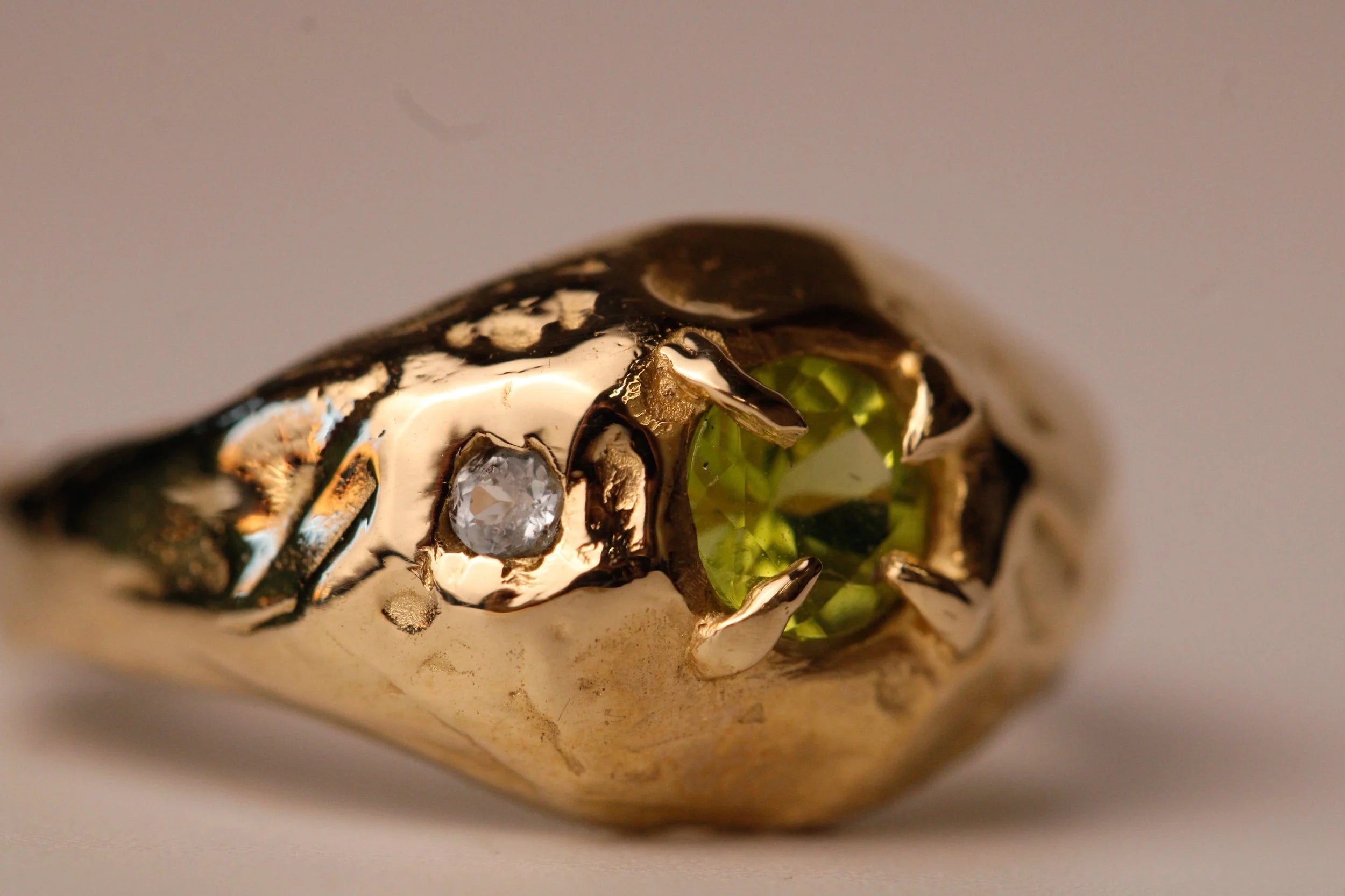 Gold ring with a green gemstone and diamond