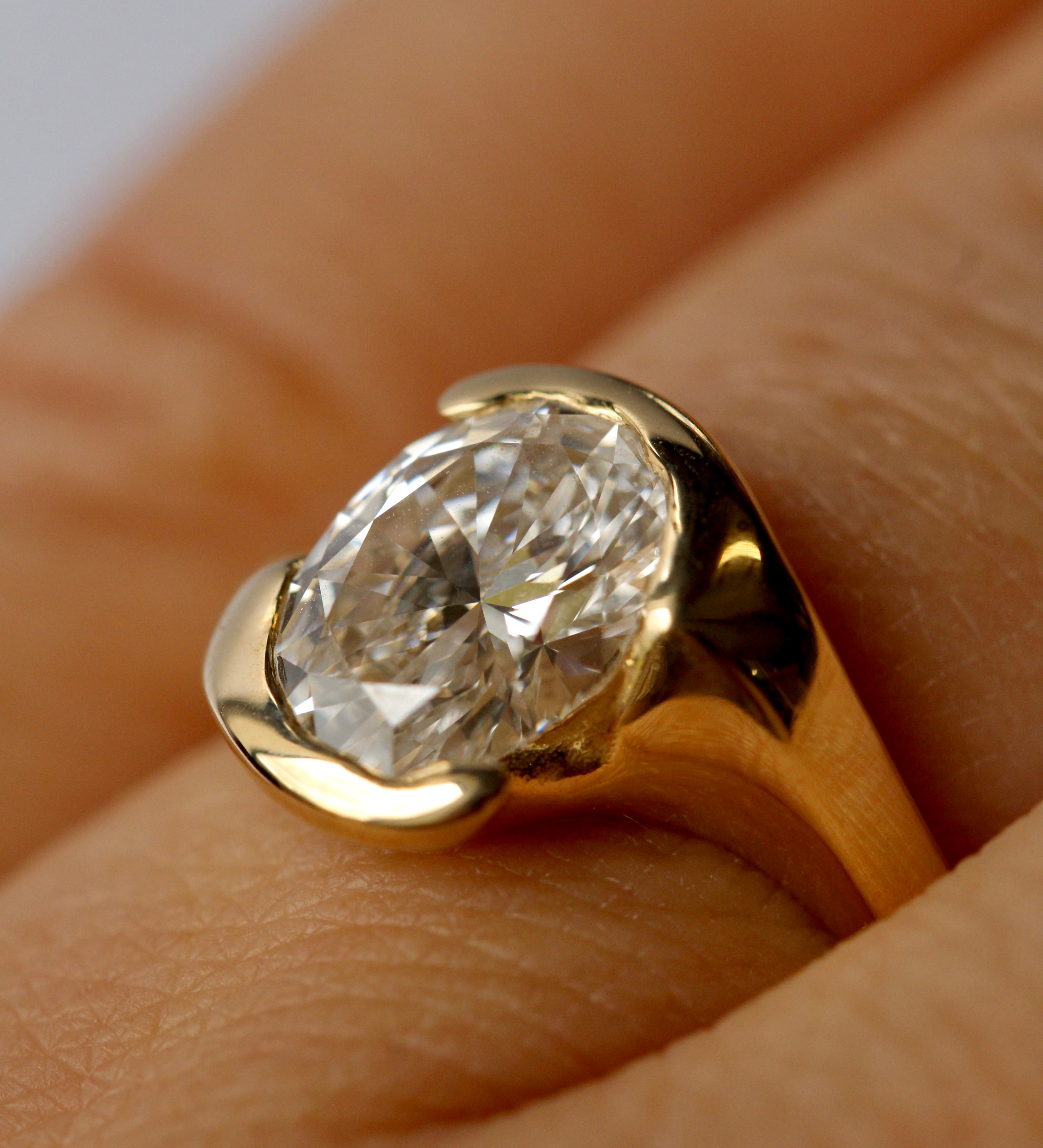 Gold ring with a large diamond on a finger